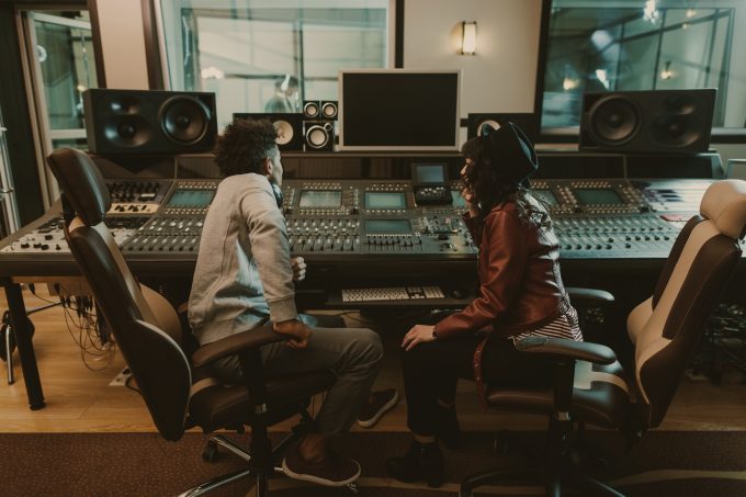 sound producers sitting at recording studio and discussing