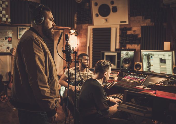 Professional music band recording song in boutique recording studio.